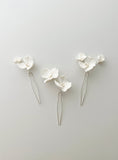 Load image into Gallery viewer, Three white floral hairpins on a light gray background
