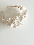 Load image into Gallery viewer, Floral headband with white flowers on a light gray background
