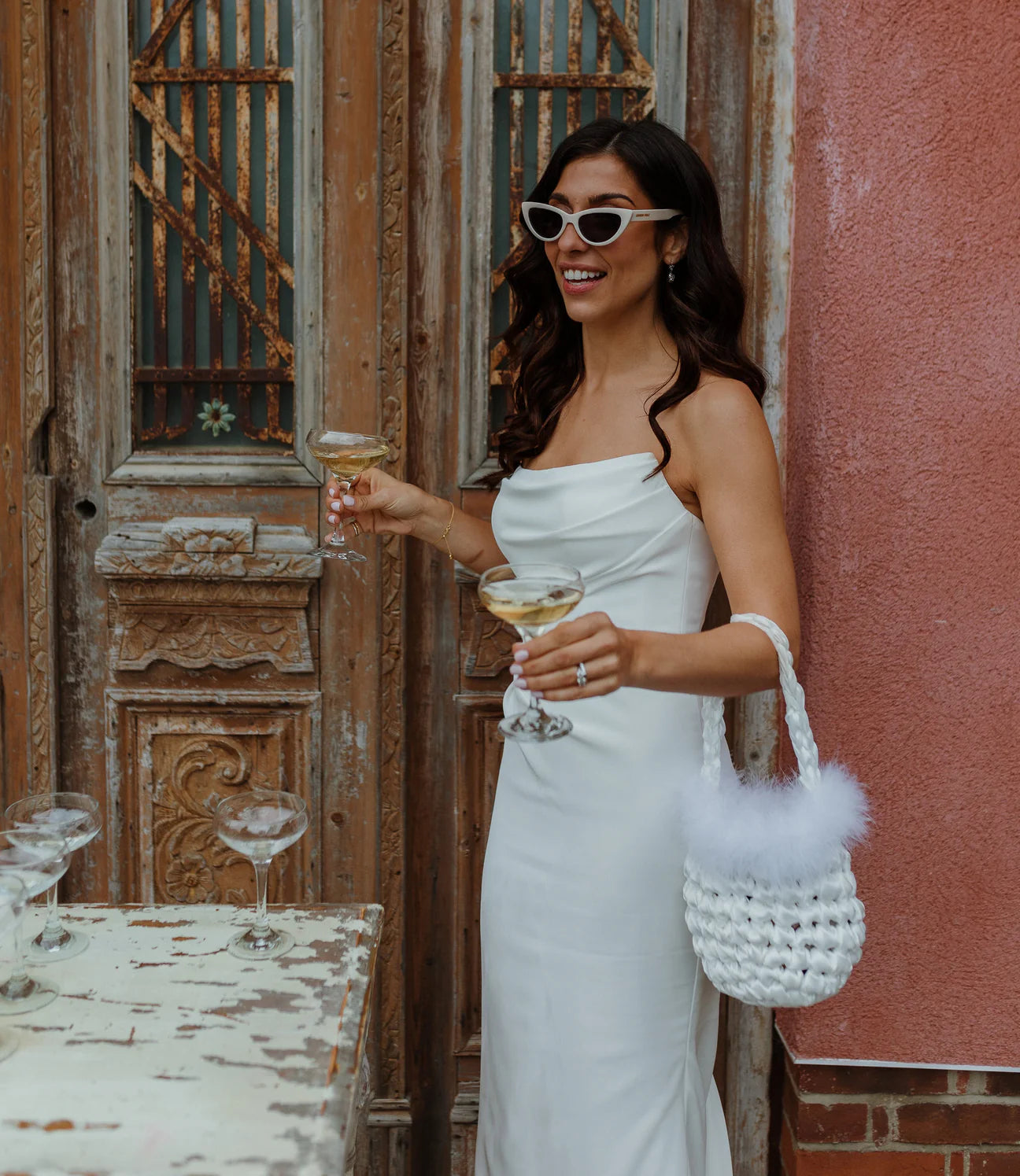 bride wearing hive feather trim handbag in white