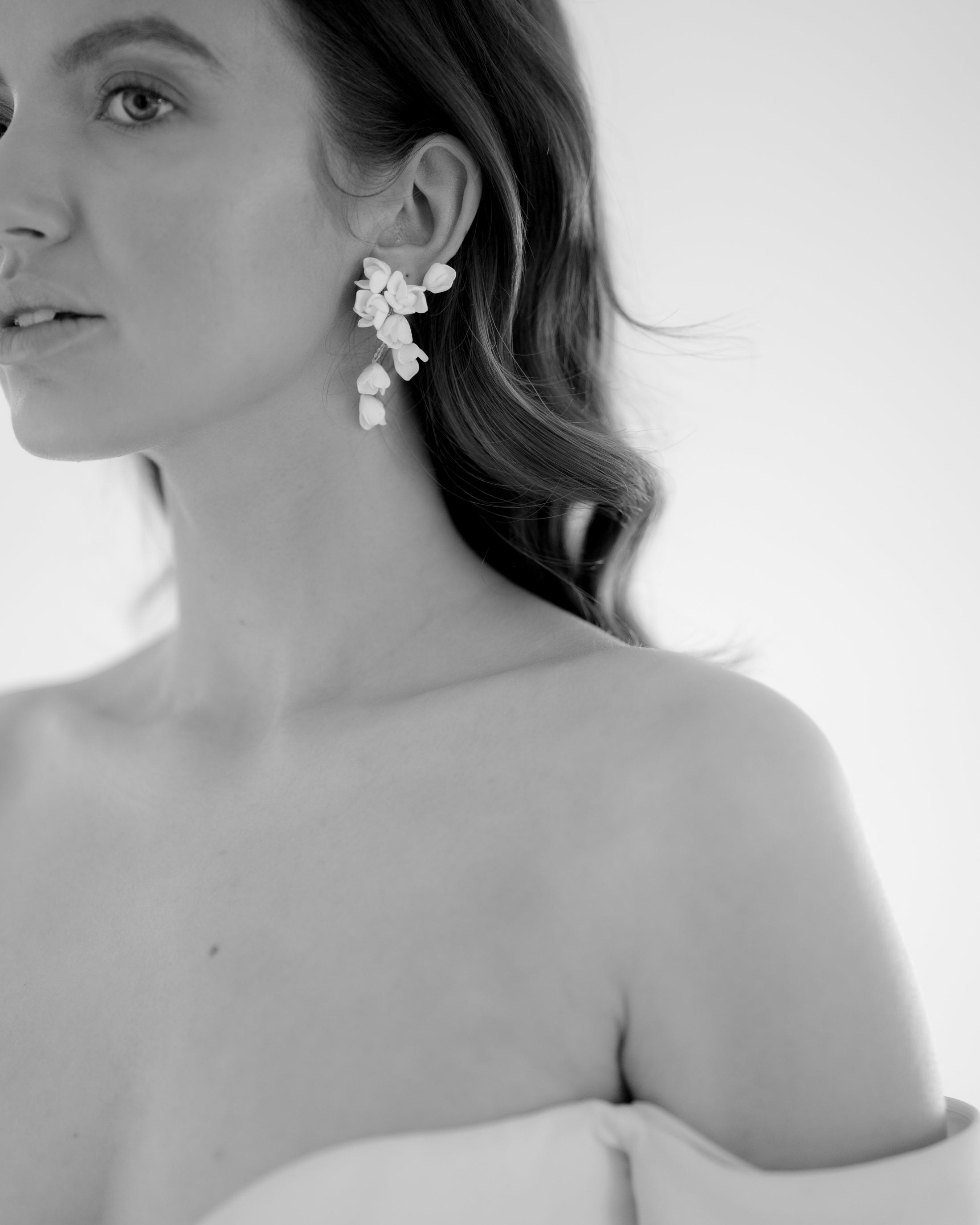 Woman wearing floral earrings with a plain background