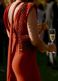 Load image into Gallery viewer, Person wearing a red dress with a beaded bridal handbag, holding a glass of champagne.
