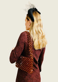 Load image into Gallery viewer, Woman wearing a burgundy dress with a unique back design and a decorative bridal handbag.
