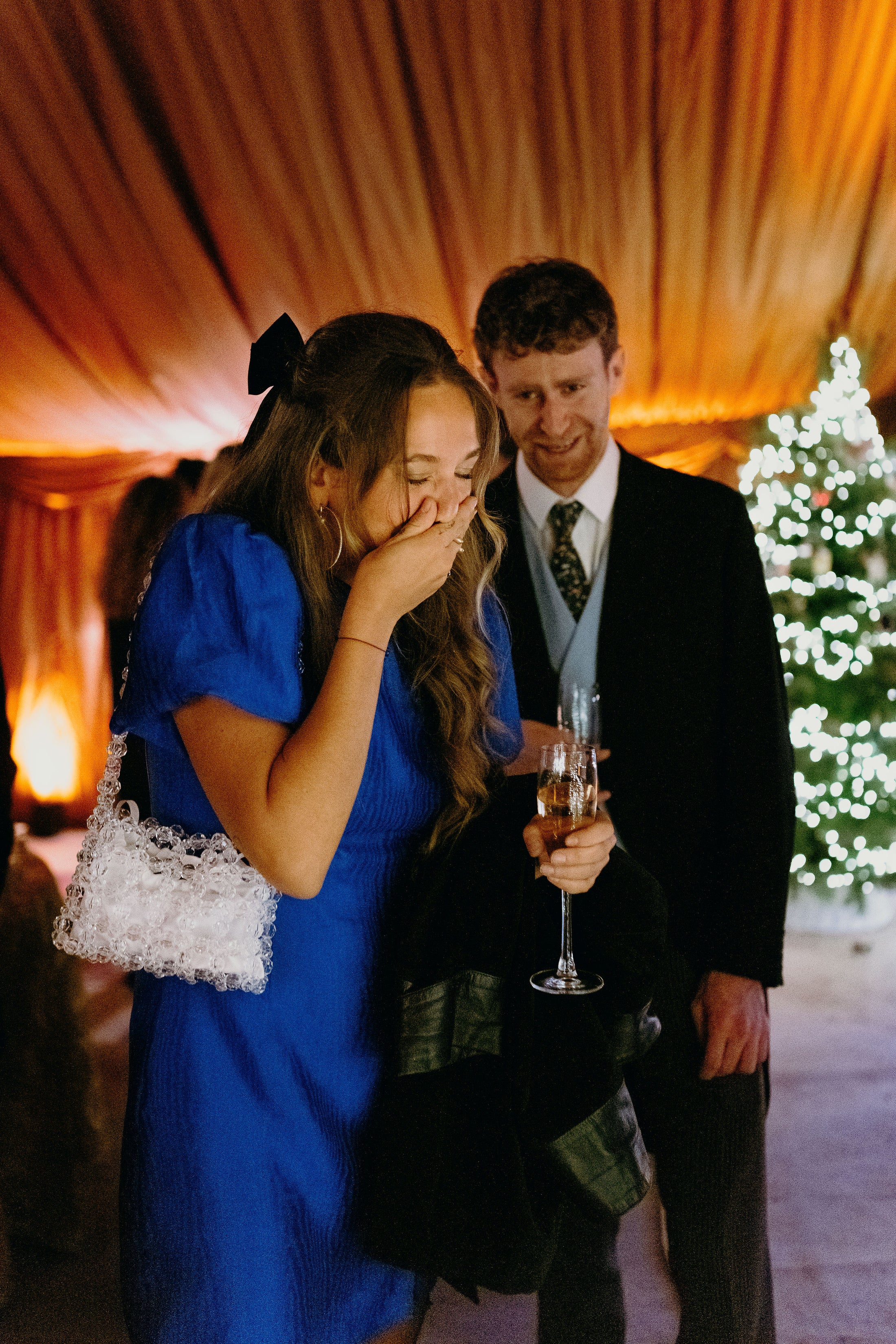 woman in a blue dress wearing a bridal bag