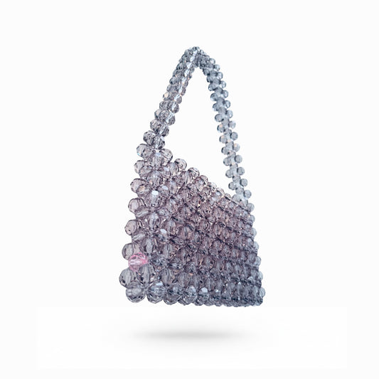 Sparkling bridal bag with beaded handle on a white background