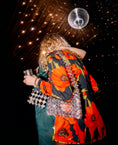 Load image into Gallery viewer, Person wearing a colorful floral jacket with a disco ball and sparkles in the background wearing a bridal bag
