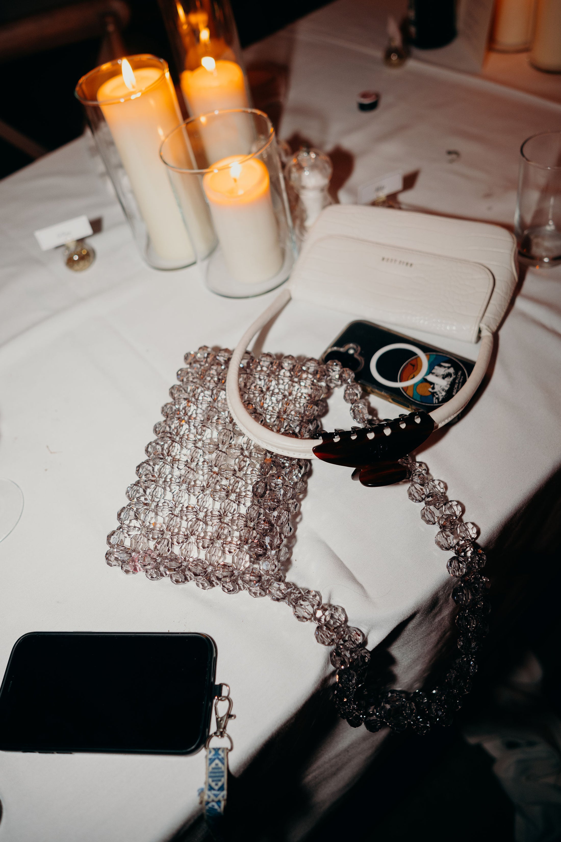 Sparkly bridal bag on a table with candles and a phone