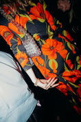 Load image into Gallery viewer, Person wearing a colorful floral dress with a close-up of their hand wearing a bridal bag
