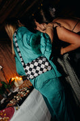 Load image into Gallery viewer, Woman in teal outfit with black and white bridal bag at a party.
