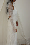 Load image into Gallery viewer, White lace veil and wedding dress on a wooden floor with a plain white wall background
