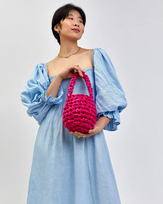 woman holding Hive bridal handbag in hot pink