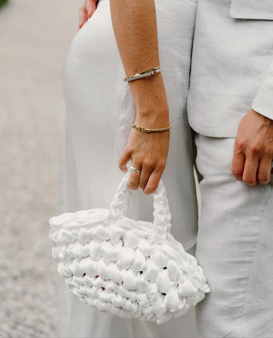 bride holding nest handbag in white