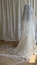 Load image into Gallery viewer, Long white wedding veil with a person partially visible behind it against a neutral background.
