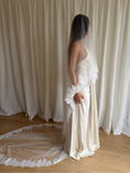 Load image into Gallery viewer, person in a wedding dress with a long lace trim veil against a curtain backdrop.
