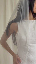 Load and play video in Gallery viewer, Person wearing a white wedding dress with a long plain veil against a plain background

