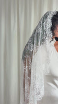 Load and play video in Gallery viewer, Person wearing a white wedding dress with a long lace veil against a plain background
