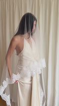 Load and play video in Gallery viewer, person in a wedding dress with a long lace trim veil against a curtain backdrop.
