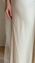 Load and play video in Gallery viewer, Bride wearing a white wedding dress with a lace veil against a white curtain background.
