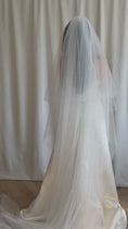 Load and play video in Gallery viewer, Bride wearing a white strapless gown with a long veil against a neutral background
