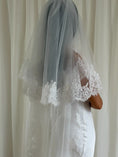 Load image into Gallery viewer, Bride wearing a white lace veil against a neutral background
