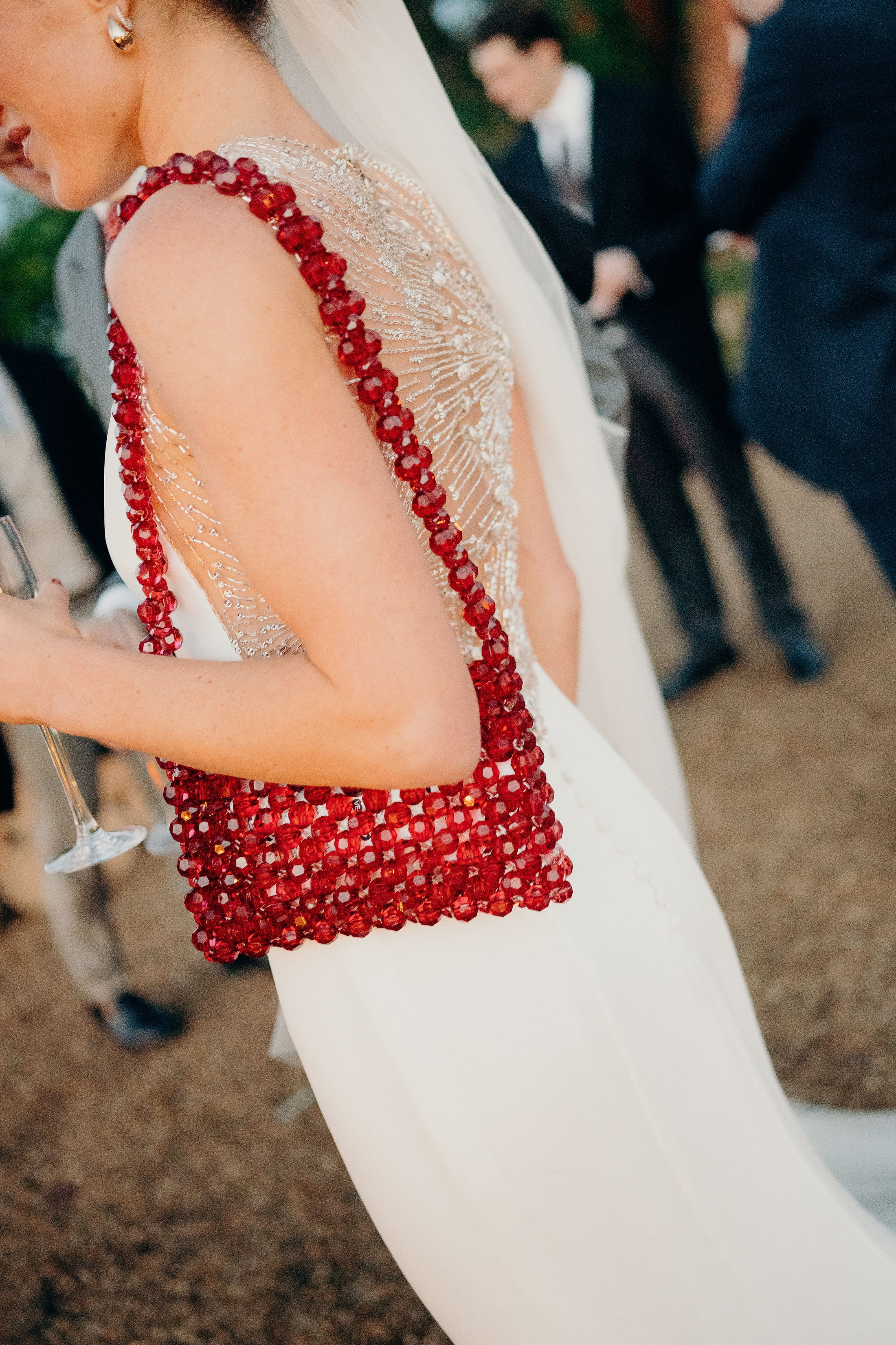 Person wearing a beaded dress and beaded bridal bag with a blurred background
