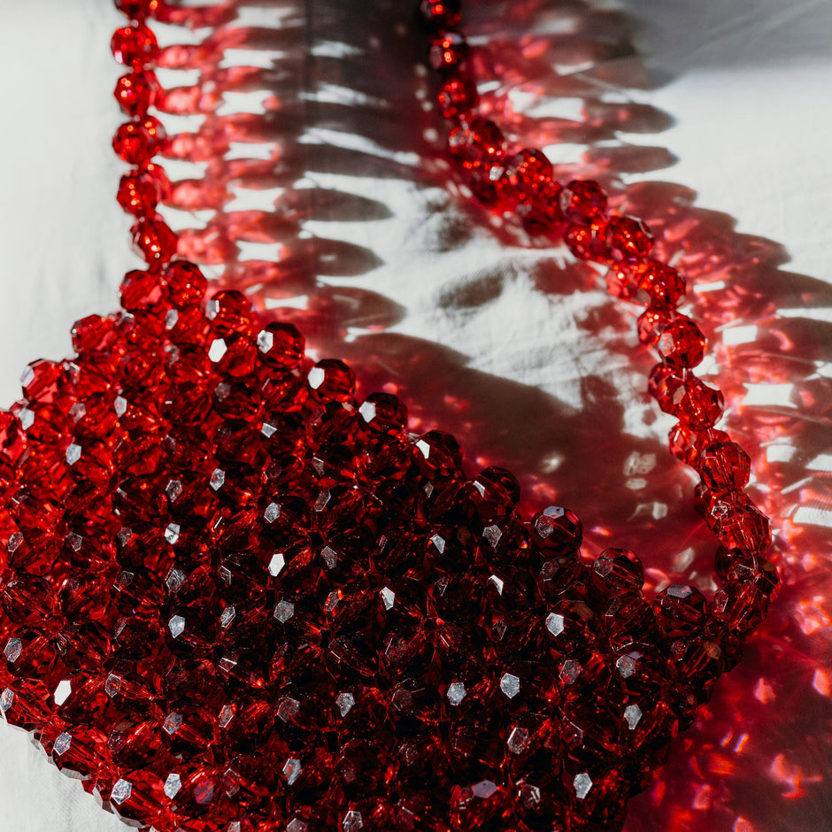 Red beaded bridal bag on a white surface